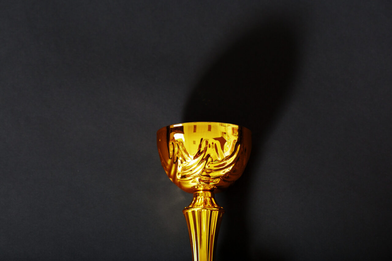Gold trophy on a dark background representing top quality and recognition