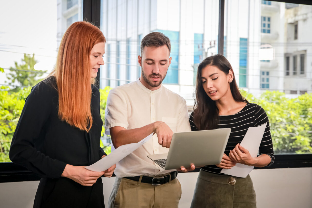 Business colleagues reviewing information together on a laptop in a modern office