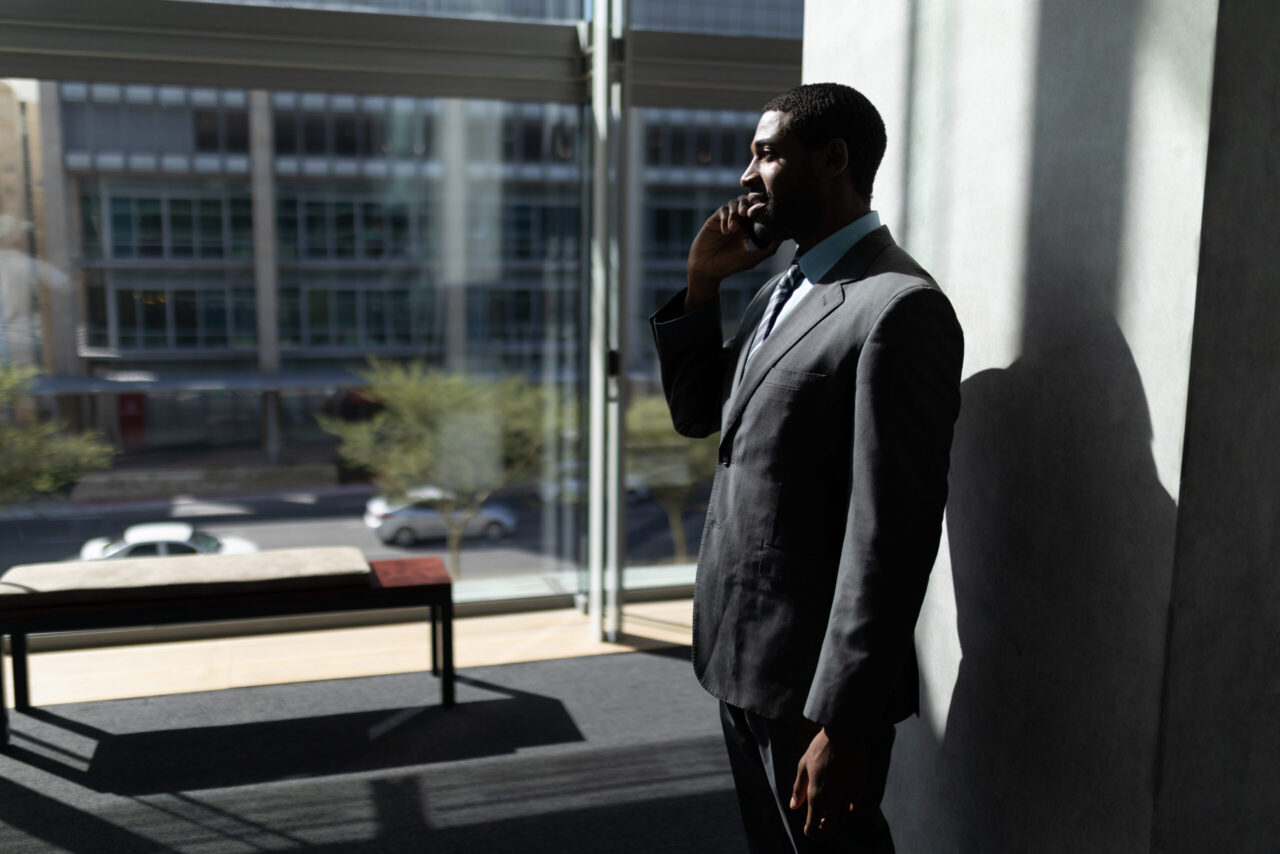 Businessman standing in a modern office while talking on a mobile phone